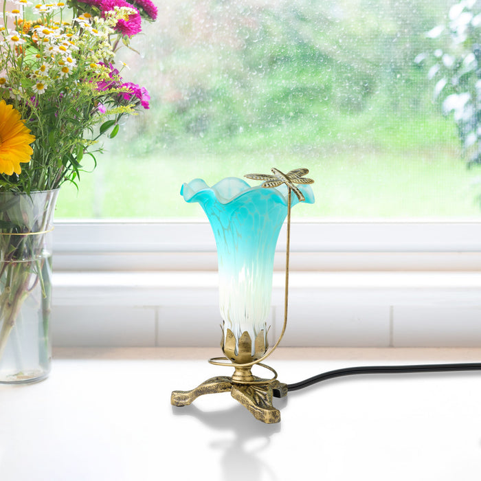 9"H Handpainted Glass Dragonfly Lily Lamp next to a vase of flowers by a window.