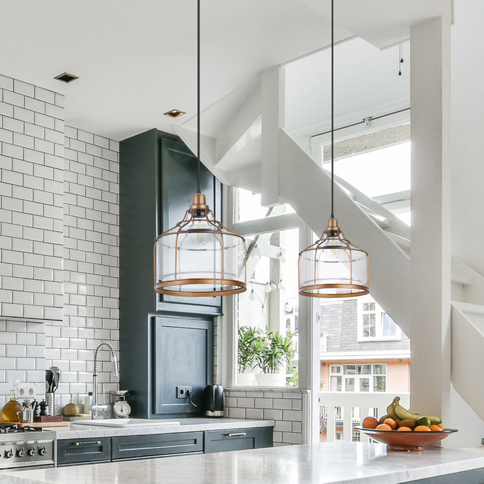 Bernadette Brass Metal and Clear Glass Pendant Lamp in a modern kitchen with white tiled walls and a staircase in the background.