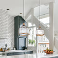 Bernadette Brass Metal and Clear Glass Pendant Lamp in a modern kitchen with white tiled walls and a staircase in the background.