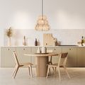Brigitta 20"W Tiered Cream Jute Pendant Light in a modern kitchen with a round wooden dining table and chairs and neutral color scheme.