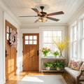 Carrie River of Goods Oil-Rubbed Bronze Metal 2-Light 52-Inch Ceiling Fan in a foyer with wooden doors and decorative elements.