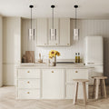 Fatima 8"W Silver Cutout Drum Pendant Lights in a modern kitchen with light wood cabinets, white refrigerator, and wooden stools.