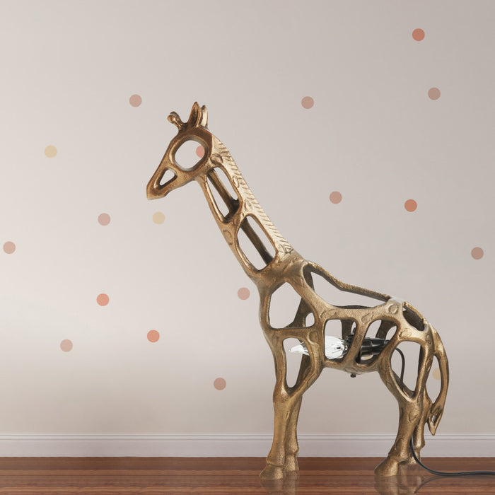 Giraffe 20 in. H Gold Sculptural Accent Lamp on a wooden table with a polka dot wall in the background