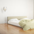 Leticia White Metal and Champagne Gold Glass Bowl 61-Inch Floor Lamp in a bedroom with a bed and light-colored walls