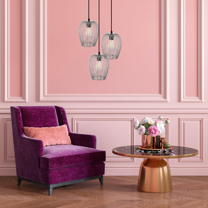 Lucinda 7.25"W Modern Silver Woven Metal Pendant Lights above a purple armchair with a pink pillow in a room with pink walls and a gold table.