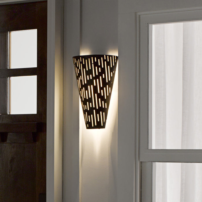 Noah Black Matte Metal Cone-Shaped Outdoor Wall Sconce on a wall with a door in the background