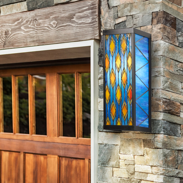 Blue Stained Glass and Black Metal Rectangular 1-Light Outdoor Wall Sconce on a stone wall next to a wooden door
