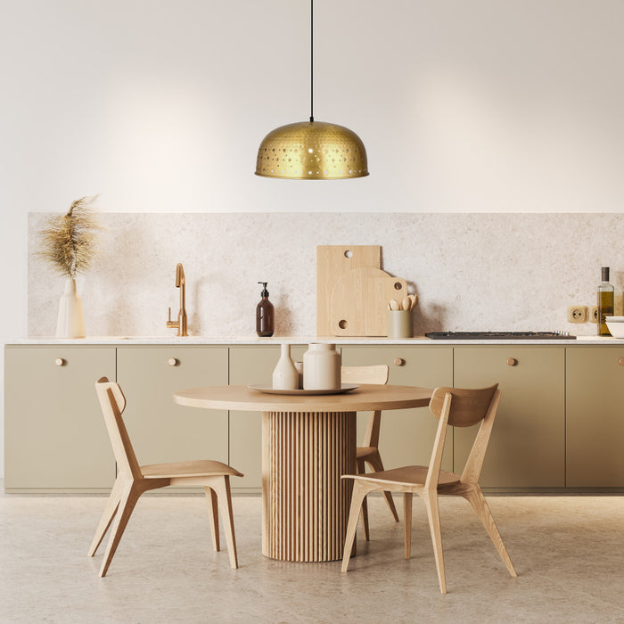 Sibyl 17.75"W Star-Shaped Cutout Gold Pendant Light hanging in a dining area with a round wooden table and chairs and kitchen cabinets.